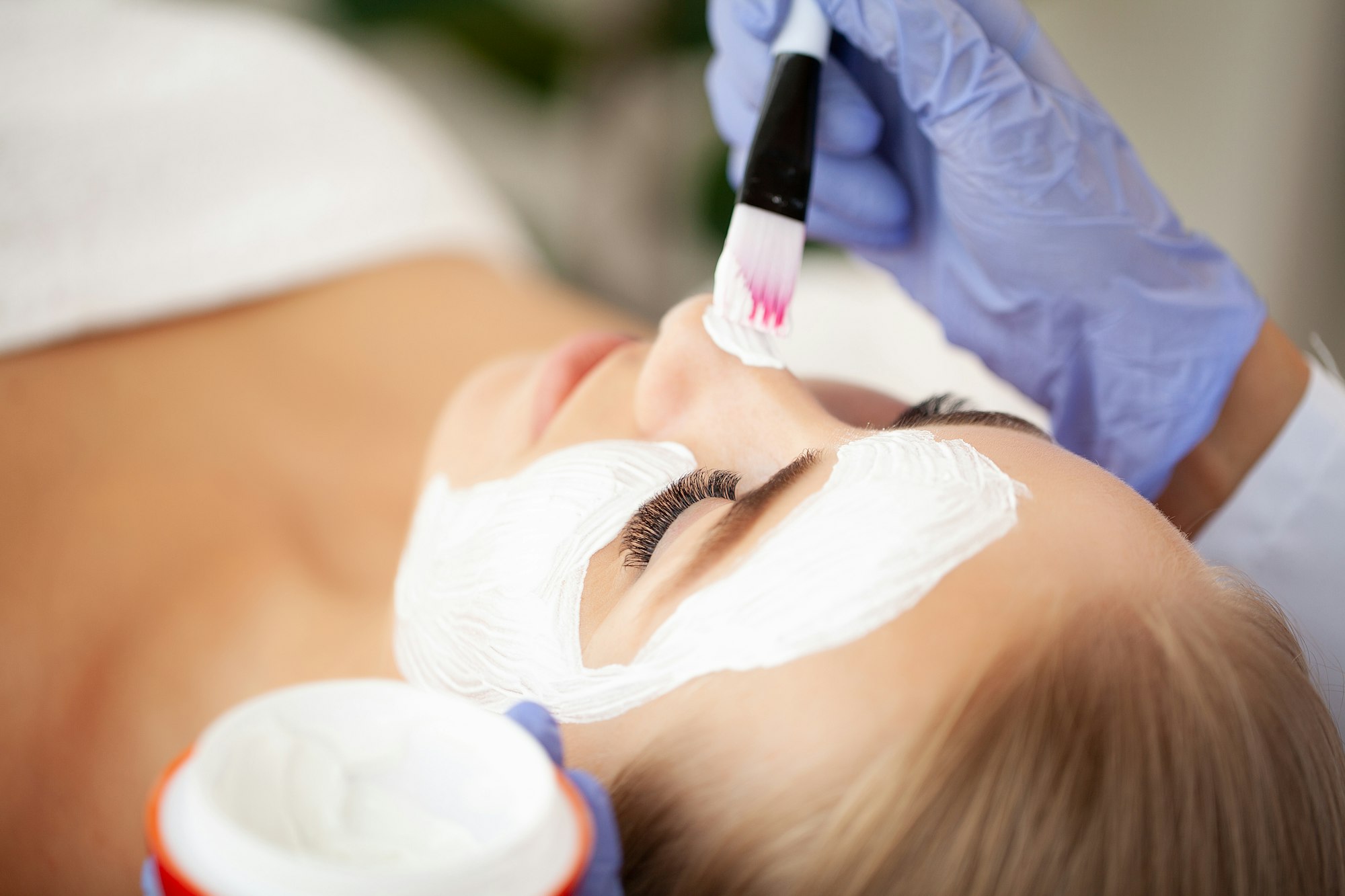 Spa Woman applying Facial cleansing Mask, Beauty Treatments