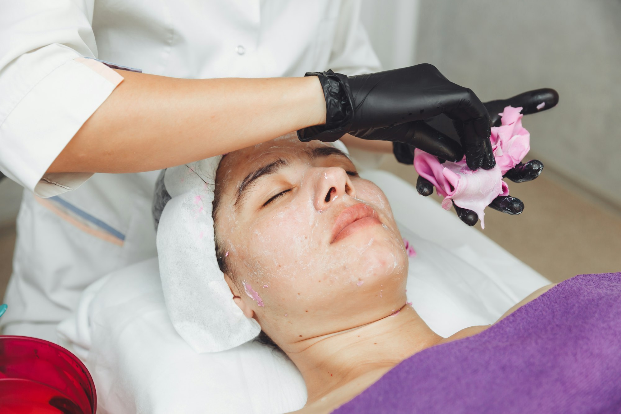 The process of removing the alginate mask from a woman's face. Facial rejuvenation procedure.